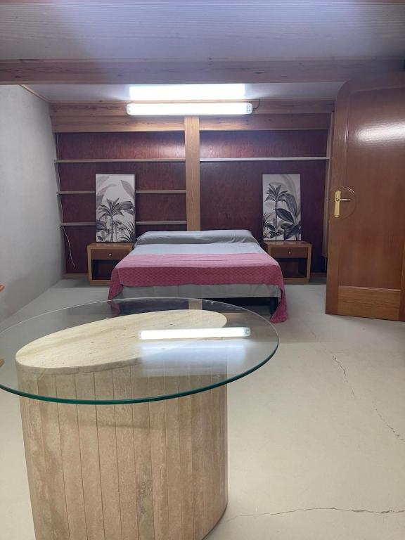 a room with a bed and a glass table at Habitaciones Espacio in Corbera de Alcira