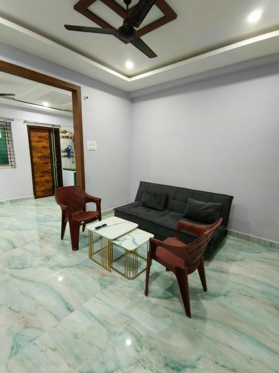 a living room with a couch and a table and chairs at Comfortable Budget Stay at ServoStay NonAC Rooms in Tirupati Ideal for Pilgrims in Tirupati