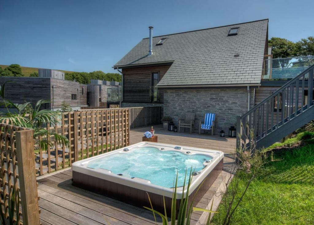 a hot tub on a deck in front of a house at House 34 in Looe