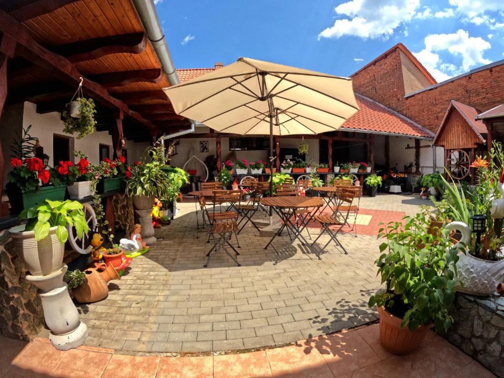 an outdoor patio with tables and chairs and plants at Mehadica House in Mehadica
