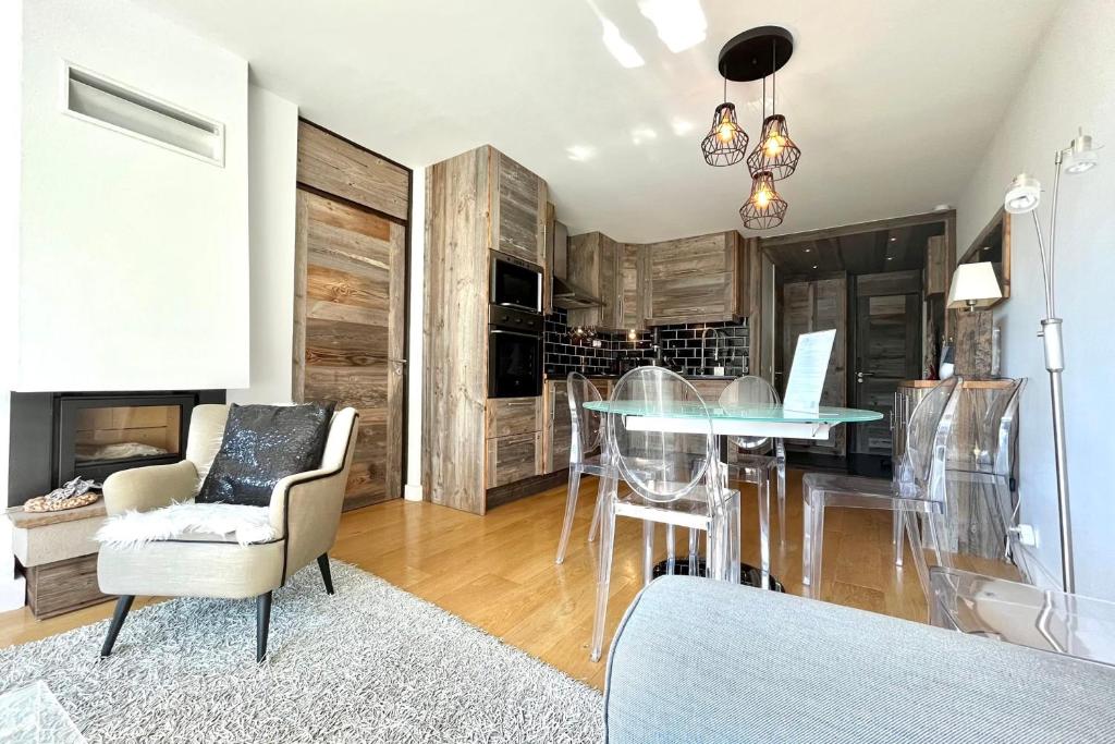 sala de estar con mesa de cristal y comedor en Le Repère de l'Ours, en Megève