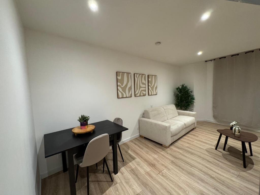 een woonkamer met een tafel en een bank bij Studio Cosy in Saint-Gaudens