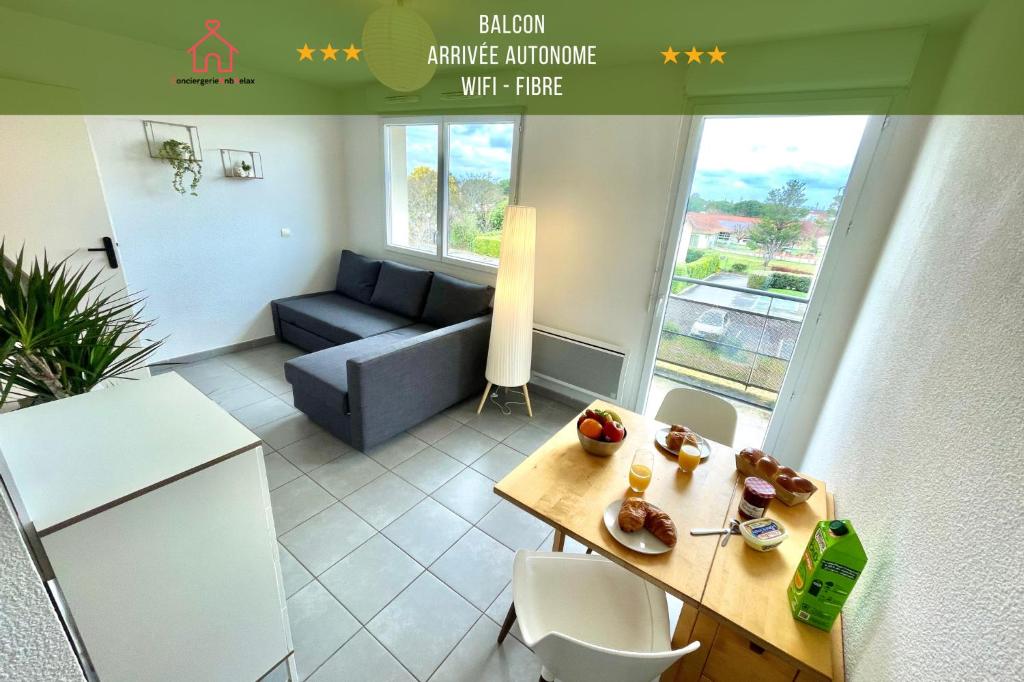 Una pequeña sala de estar con un sofá y una mesa. en " Le nid de Peyramont " Centre ville - Balcon - WiFi, en Muret
