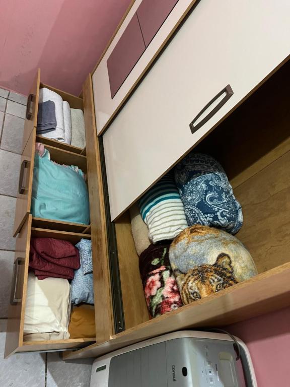 ein Schrank voller Handtücher und Kissen in der Unterkunft Santa Maria de Nazaré in Anápolis