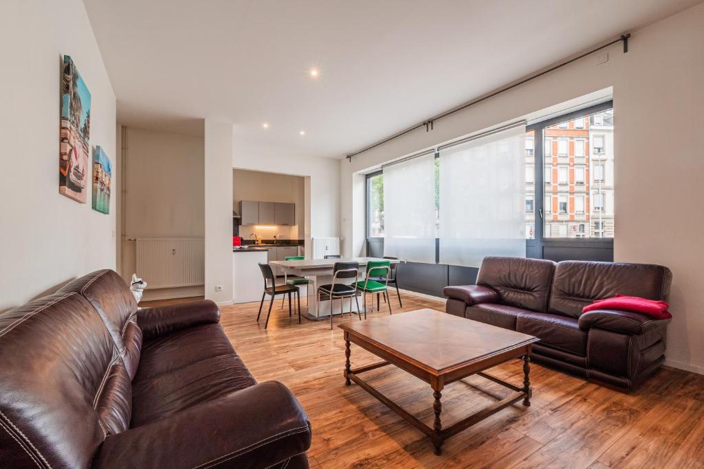 un salon avec un canapé et une table dans l'établissement Une Parenthèse à Strasbourg, à Strasbourg