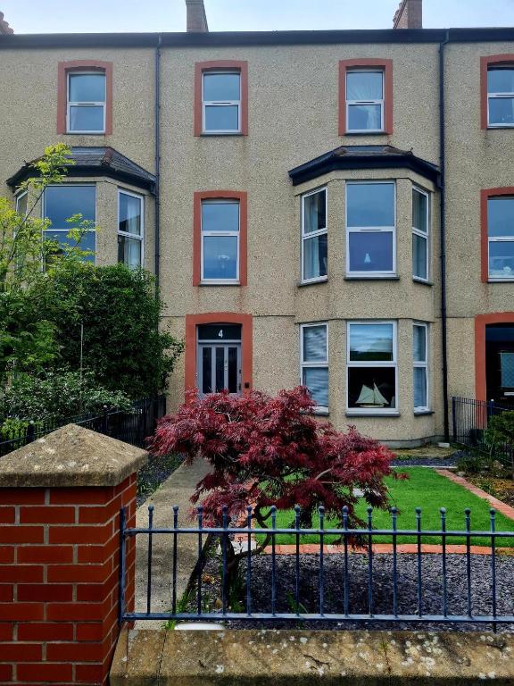 an apartment building with a tree in front of it at Leamington Beech Villa in Penmaen-mawr