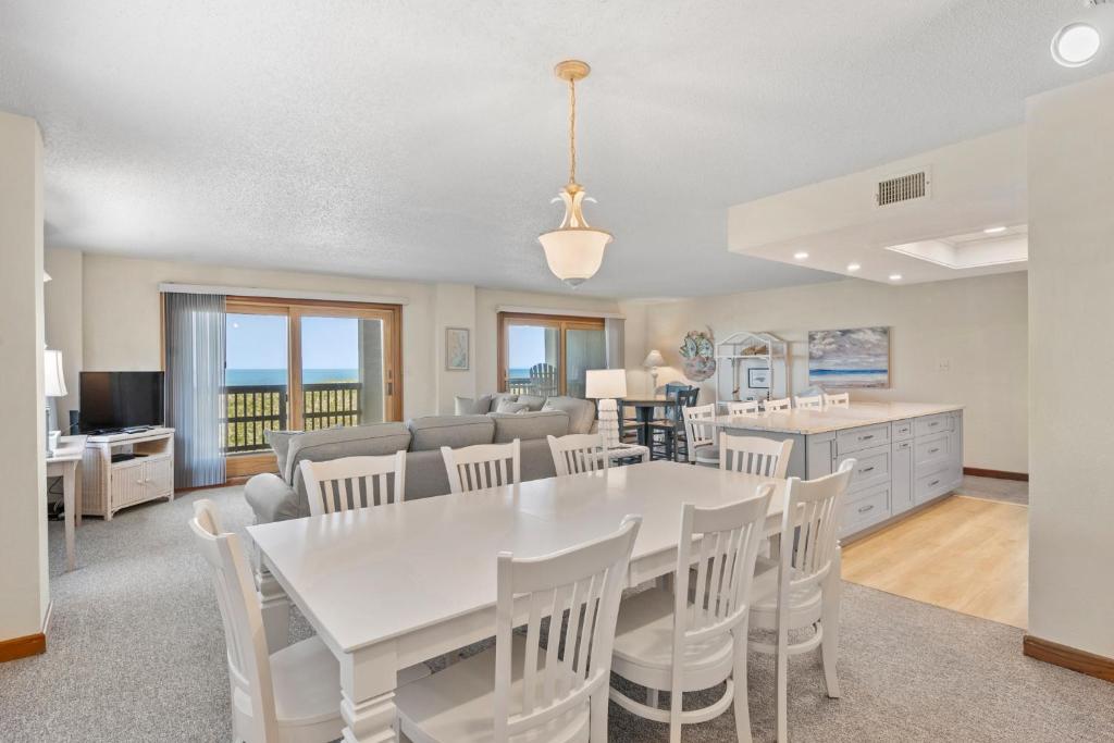 comedor y sala de estar con mesa blanca y sillas en Heron Cove 204S, en Nags Head