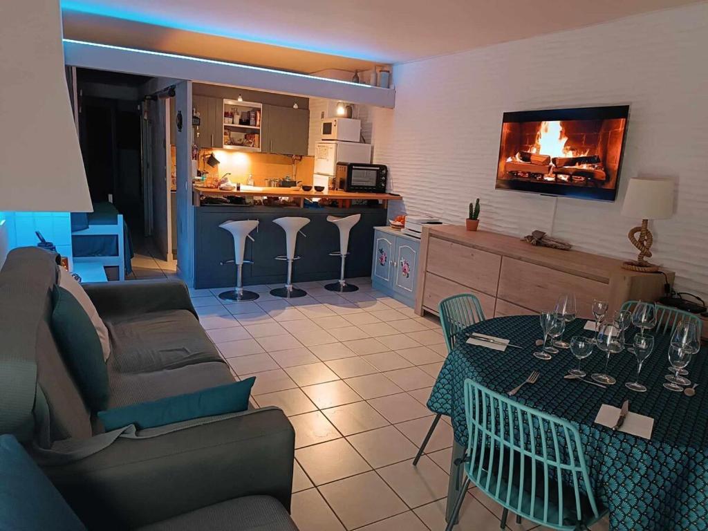a living room with a couch and a table at Appartement climatisé accès direct plage in Saint Cyprien Plage