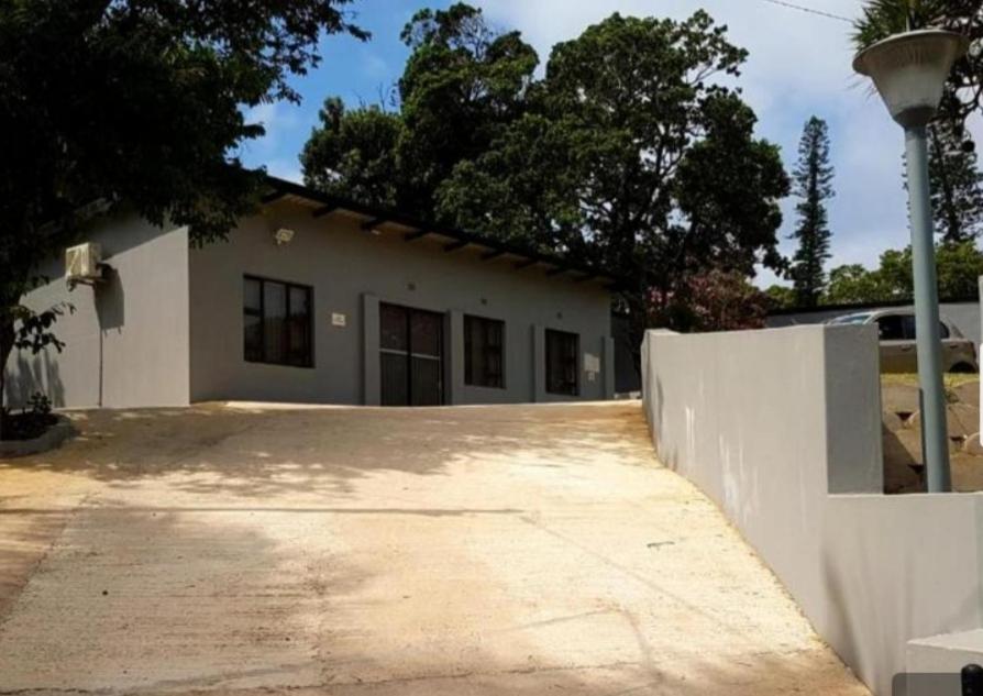 a white house with a fence and a driveway at VILLA HOLIDAYS - 14A Berea Road Margate in Margate