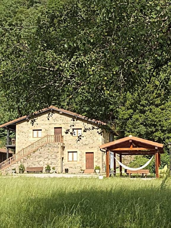 a stone building with a staircase and a house at Las Casucas del Cartero in Cantabria