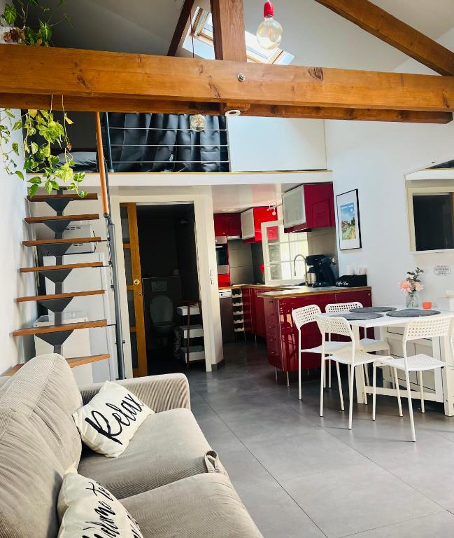 un salon avec un canapé et une table et une cuisine dans l'établissement Petite maison indépendante à 20min de Paris, à Bonneuil-sur-Marne