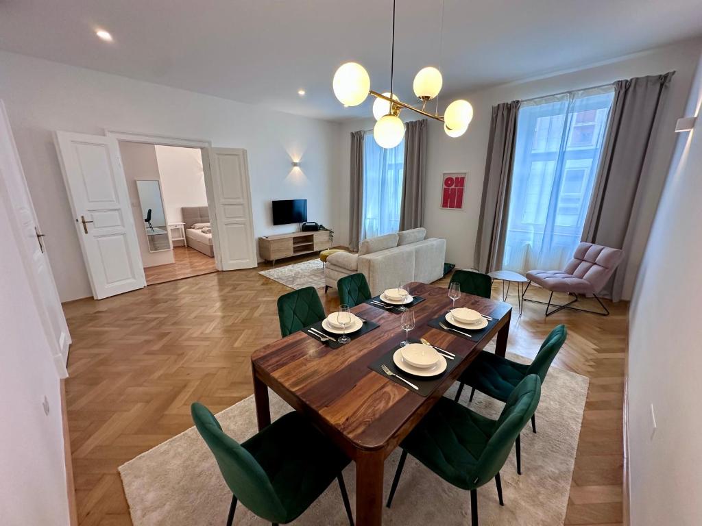 a dining room and living room with a table and chairs at Spacious Designer Apartment in heart of the town in Maribor