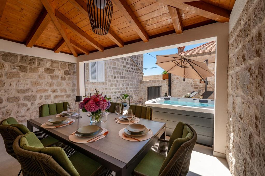 a dining room with a table and chairs and a swimming pool at Villa Mareta Cavtat in Cavtat