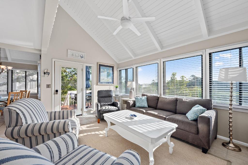 a living room with couches and a table at 818 Treeloft Cottage in Seabrook Island