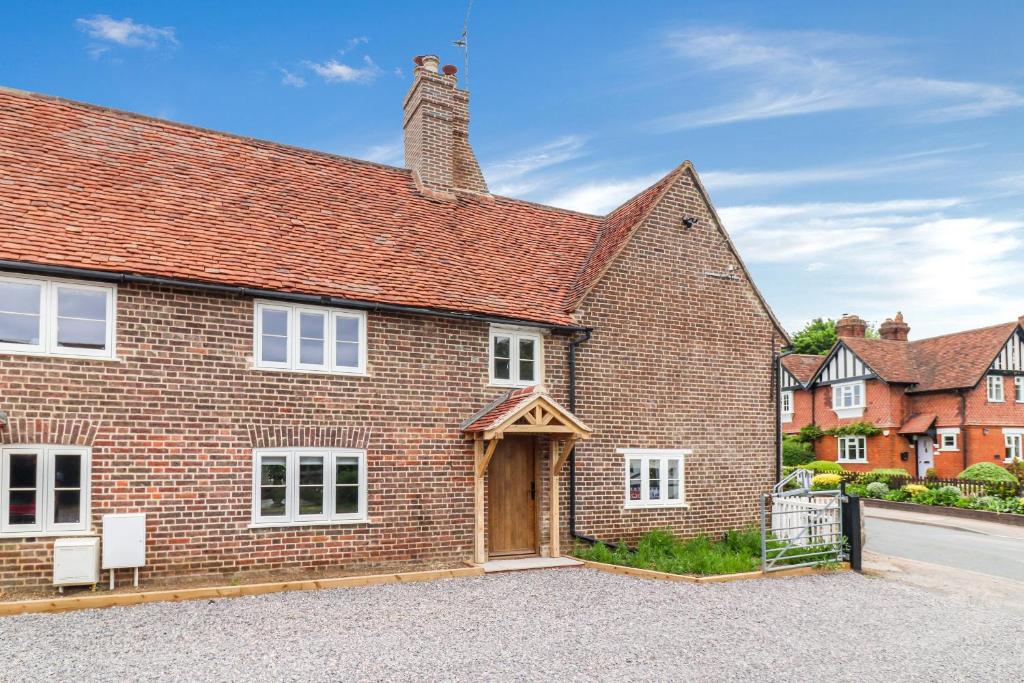 an image of a brick house with a garage at Tuffs Farm Cottage in Kings Langley