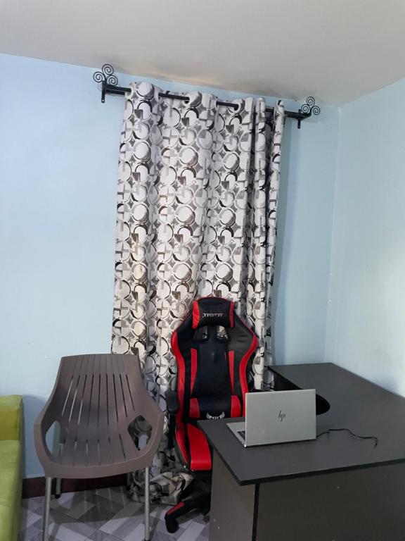 a room with a chair and a desk with a laptop at MSF BACHELOR PAd in Arusha