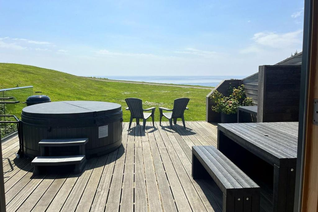 a deck with a grill and chairs and a table at House 36 in Looe