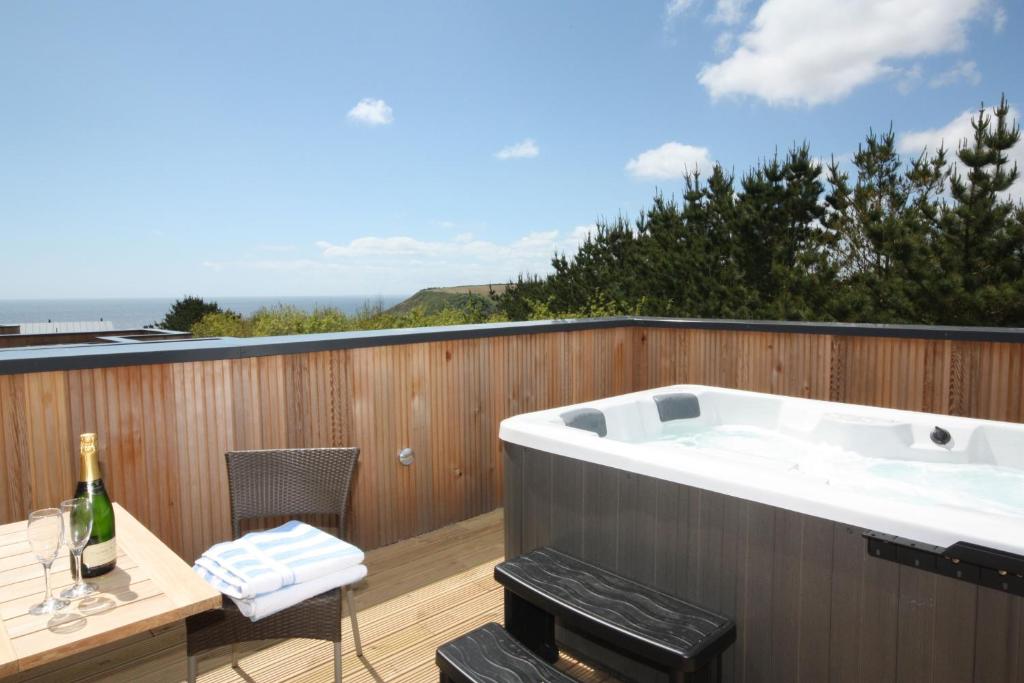 a bath tub on a deck with a table and chairs at House 47 in Talland