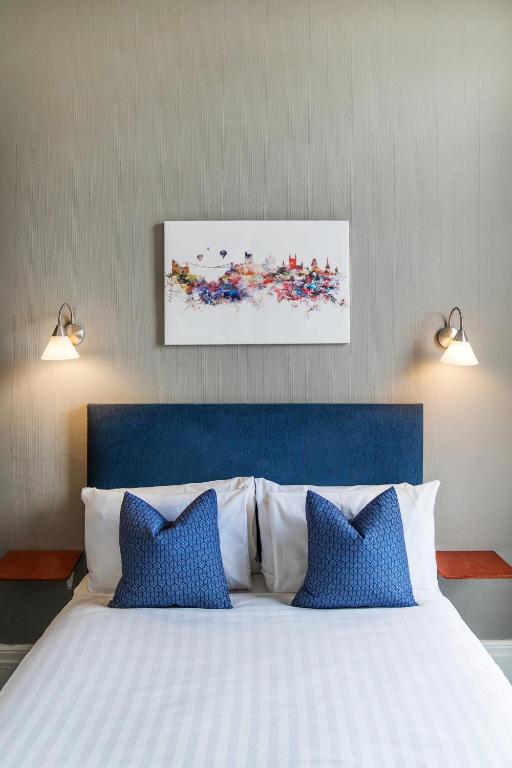 a bedroom with a large bed with blue and white pillows at The Washington in Bristol
