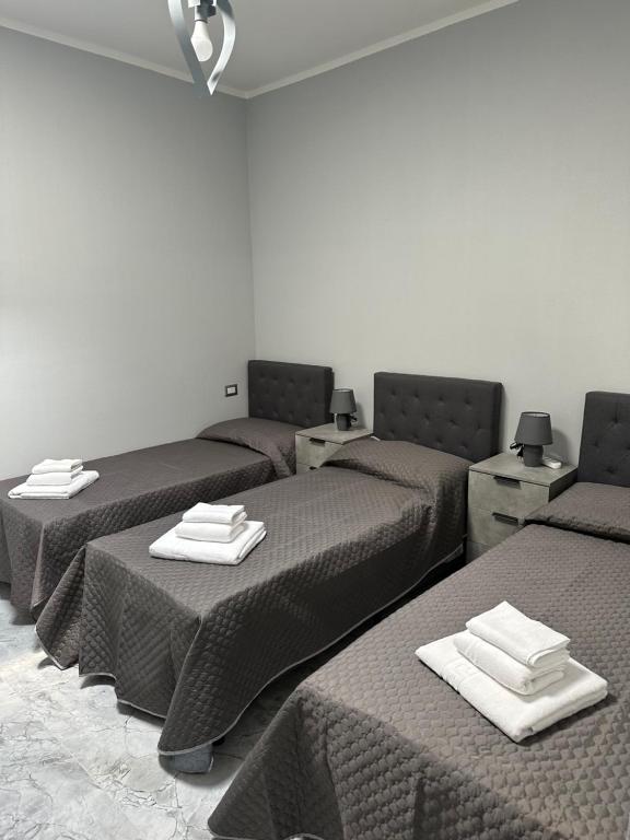 Una habitación con tres camas con toallas. en Nardhouse, en Carrao