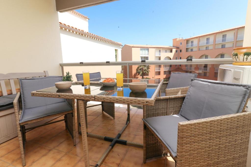un patio avec une table et des chaises sur un balcon dans l'établissement Musa by POM, clim, terrasse, au Cap d'Agde