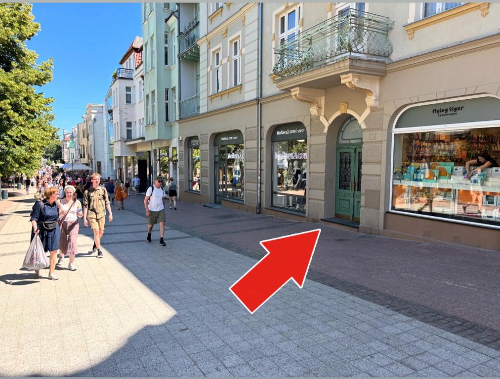 a group of people walking down a street with a red arrow at Monte Cassino 26 Piękna Kamienica 300m do Molo in Sopot