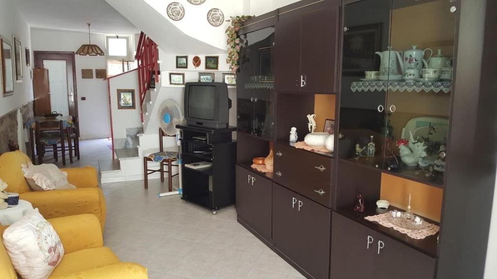 a living room with a couch and a tv at Casa di Nonna in Calasetta