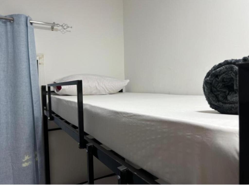 a bed in a room with a white mattress at international hoste in Muscat