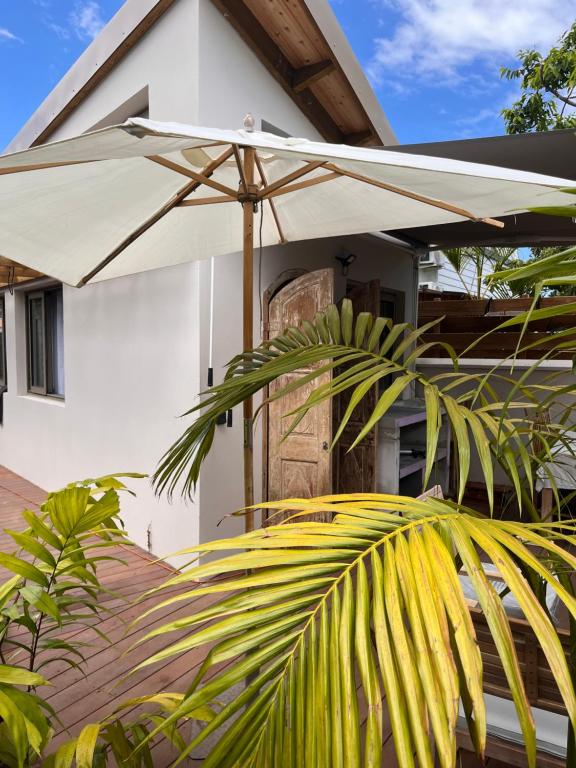 a white umbrella sitting on top of a house at Paillote Plume Bleue in Saint-Leu