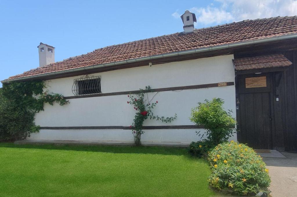 LedenikにあるGuesthouse Villa India - Bibliothekのドアと緑の庭のある白い建物