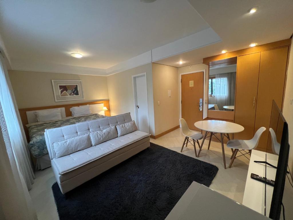 a hotel room with a bed and a table and chairs at Hotel Biena Ibirapuera UH407 in Sao Paulo