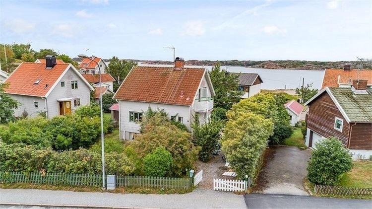 a group of houses with a lake in the background at Family-Friendly House with Garden & Terrace by the Sea in Bovallstrand