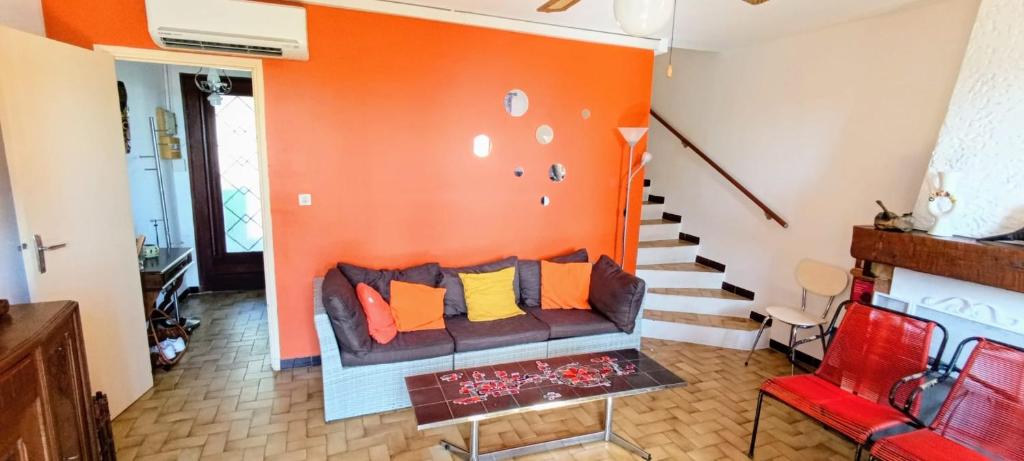sala de estar con paredes de color naranja y sofá en Pleasant house with garden near beaches, en Bandol