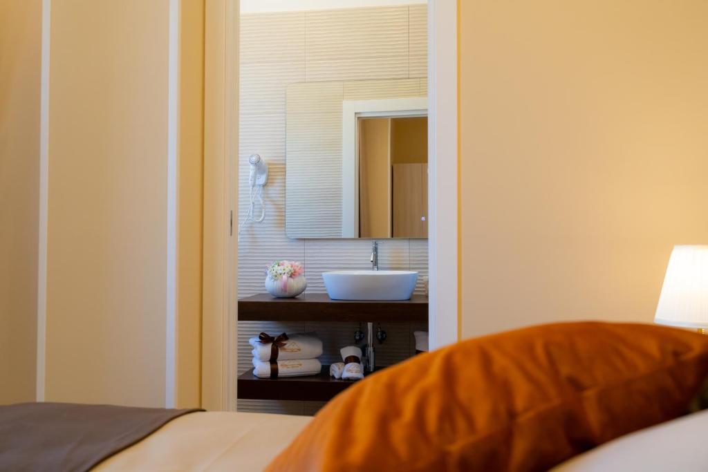 a bedroom with a bathroom with a sink and a mirror at Partenope's House in Ercolano