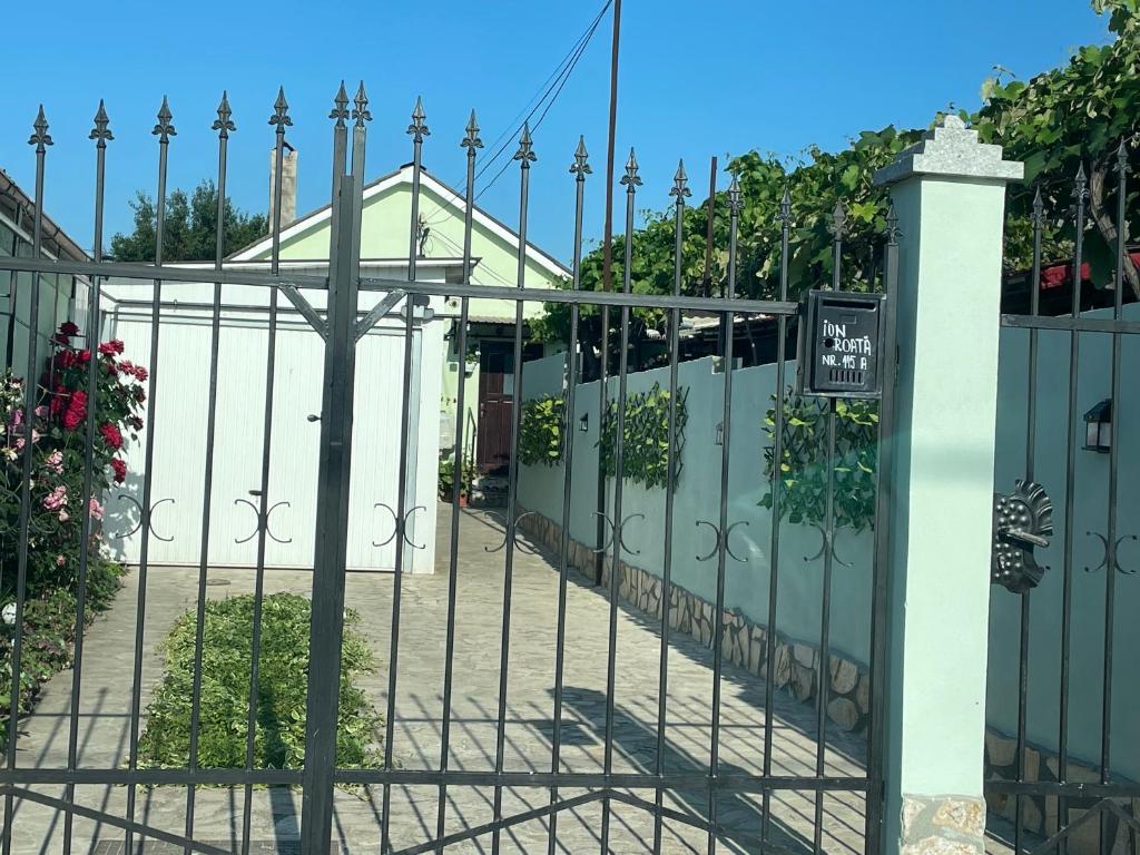 a gate to a house with a white fence at Căsuța Verde in 2 Mai