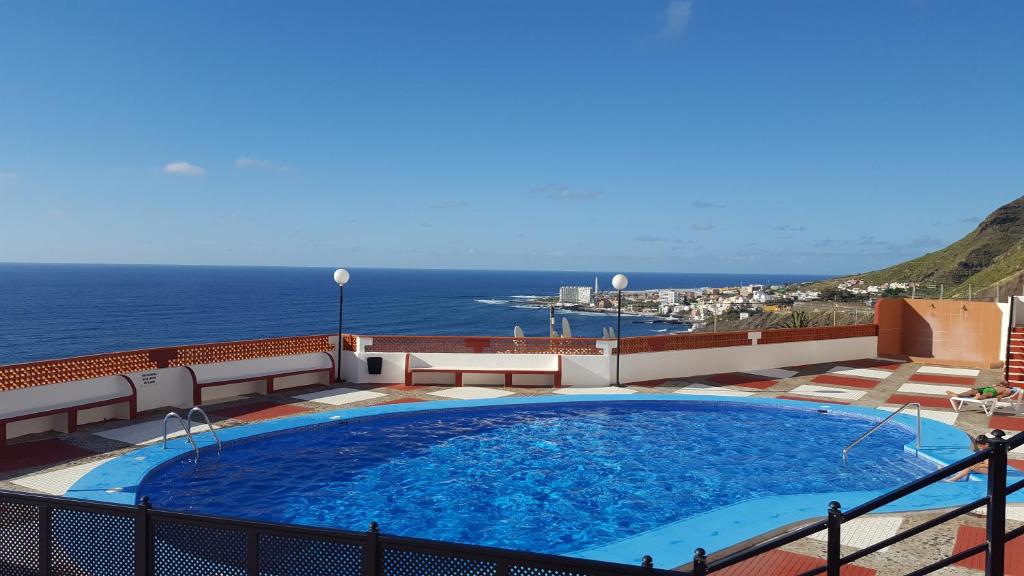 a large swimming pool on top of a building with the ocean at Altamira in Bajamar