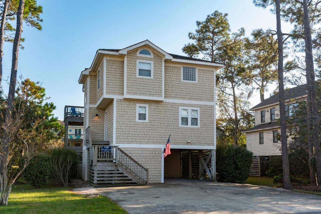 a large house with a staircase in a driveway at Good Sun-Sations in Corolla