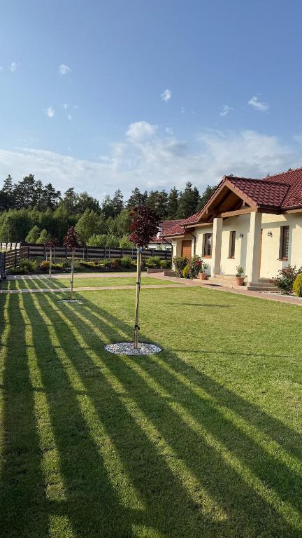 a shadow of a house on a lawn at Warmińskie Lokum in Woryty