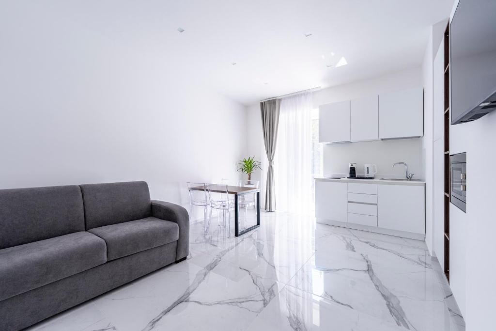 a living room with a couch and a kitchen at Alberti Apartments in Trapani