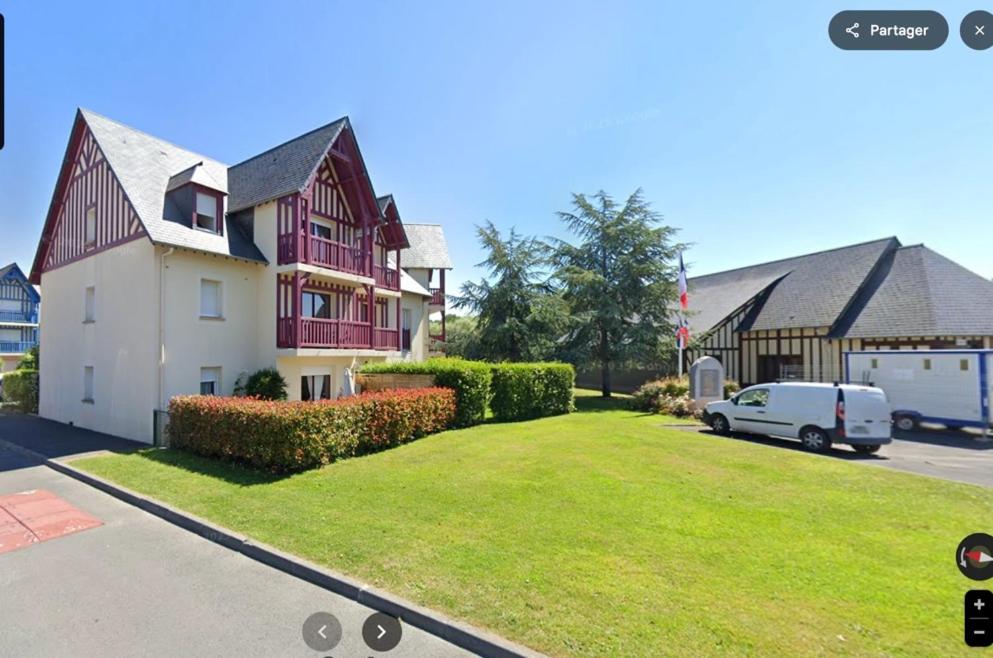 ein Haus mit einem davor geparkten Auto in der Unterkunft Rez de jardin centre Saint Arnoult in Deauville