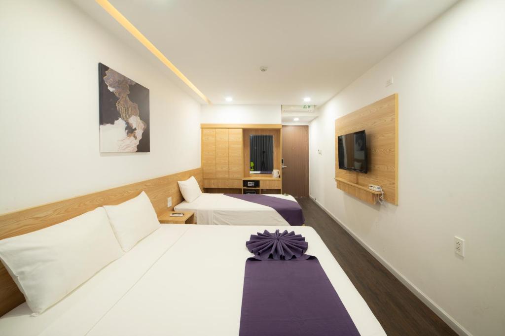 Giường trong phòng chung tại Dolphin Hotel Nha Trang