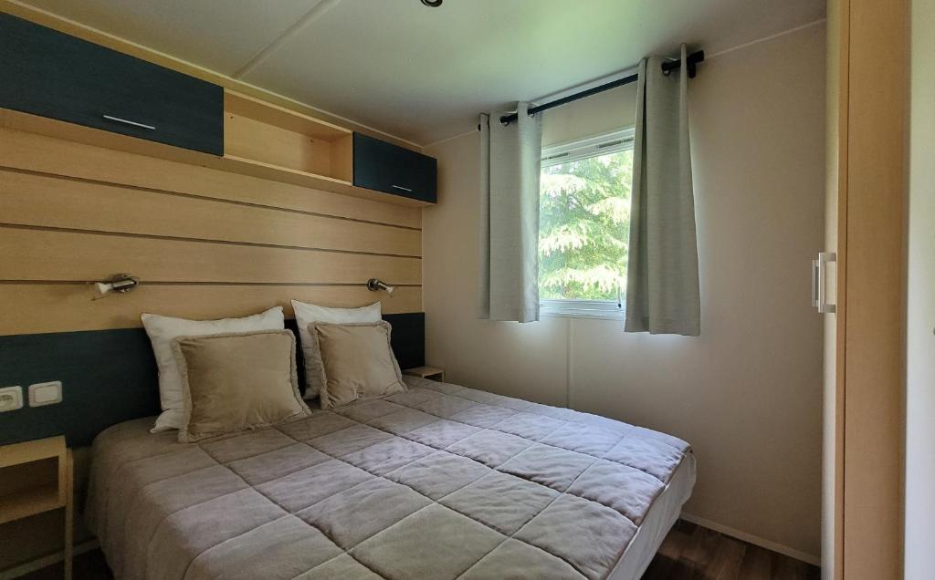 Un pat sau paturi într-o cameră la Mobil-home N 3 chambre, climatise, cuisine equipee, TV & Wi-Fi