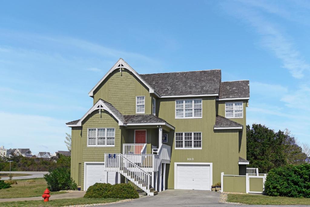 a yellow and green house with a garage at Lauren Lee in Nags Head