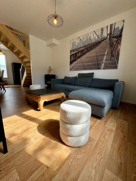 un salon avec un canapé bleu et une table basse dans l'établissement Duplex 70m2 proche mer, 2 chambres, terrasse, parking gratuit dans la rue, à Saint-Malo