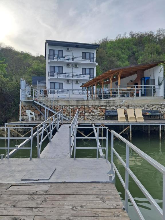 un muelle con un edificio y un edificio sobre el agua en Casa din Golful Dunării, en Eşelniţa