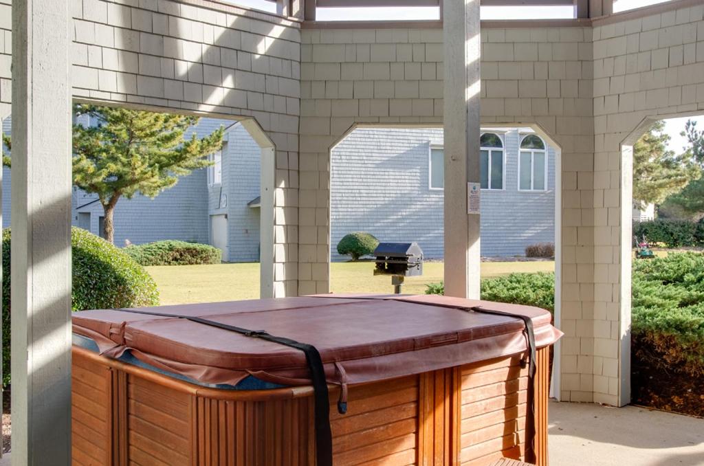 a hot tub sitting on the outside of a house at Let Me Count The Waves in Corolla
