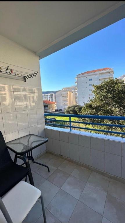 a balcony with a table and chairs on a building at Apartment Una in Becici