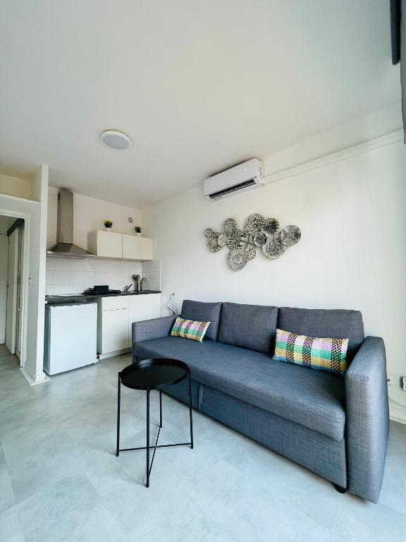 un salon avec un canapé bleu et une table dans l'établissement Nice Promenade 2, à Nice