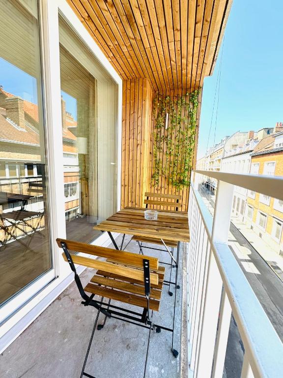d'un balcon avec un banc et une table. dans l'établissement Appartement Cosy - Hyper Centre Dunkerque, à Dunkerque