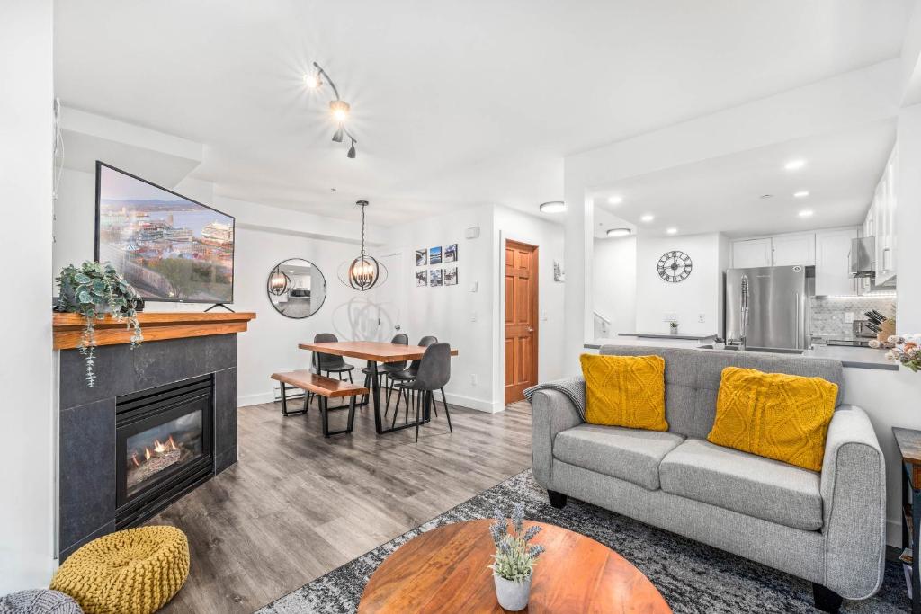 a living room with a couch and a fireplace at Amazing Village Location with PRIVATE Hot Tub in Whistler